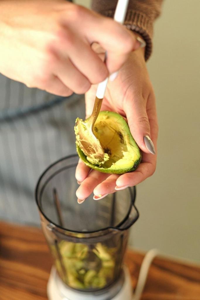 scooping avocado into a blender